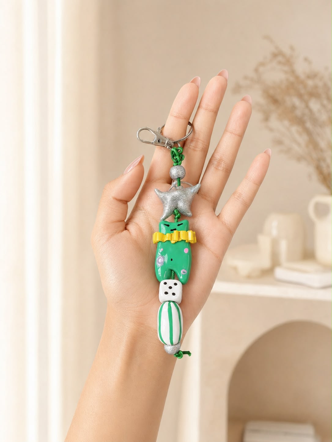 A colorful keychain charm featuring a green character figure, a silver star, a white dice bead, and a green cord clasp.

Lucky Little Frog handmade green polymer clay keychain and bag charm